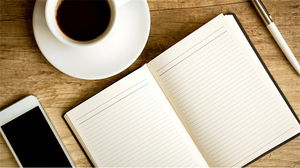 木制桌面咖啡杯记事本的PPT背景图片
